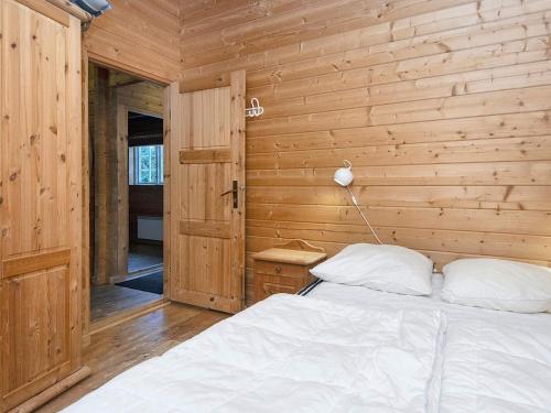a bedroom with a bed and a wooden wall at 6 person holiday home in Fårvang-By Traum in Fårvang