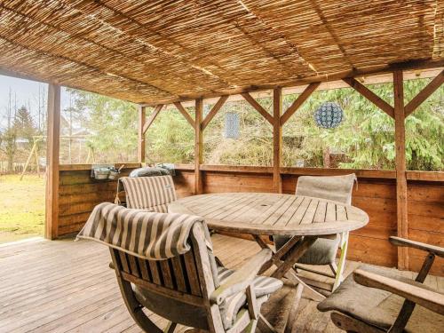 a wooden porch with a wooden table and chairs at 6 person holiday home in Fårvang-By Traum in Fårvang
