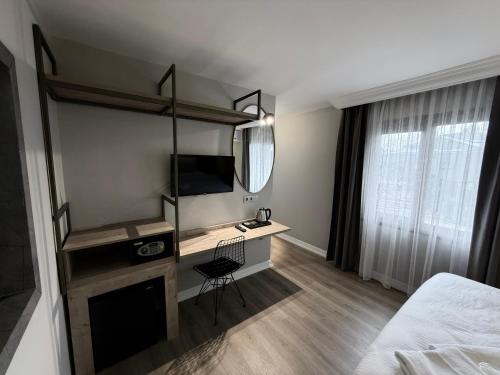 a bedroom with a desk and a bed and a mirror at OTTO X Hotel in Kavaklıdere