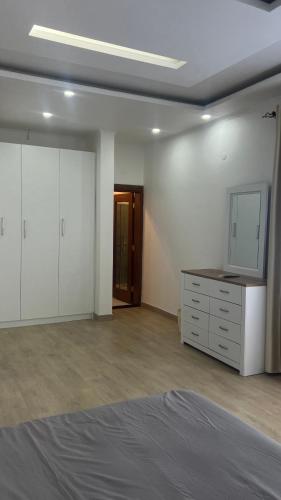 a bedroom with a bed and a dresser and a mirror at Jardim LS in Dondo