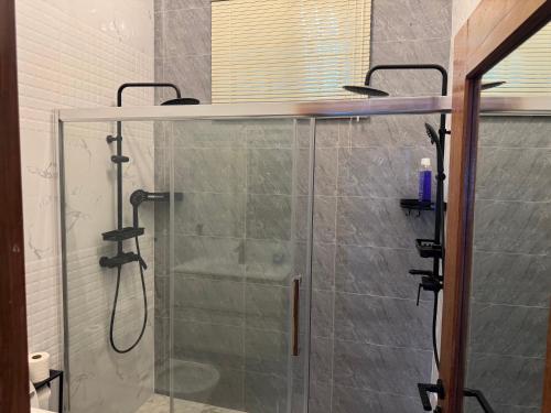 a shower in a bathroom with a glass shower stall at Jardim LS in Dondo