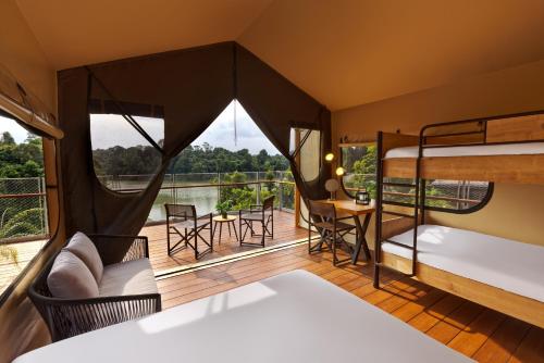 a room with bunk beds and a balcony at Colugo Camp, Mandai Wildlife East in Singapore