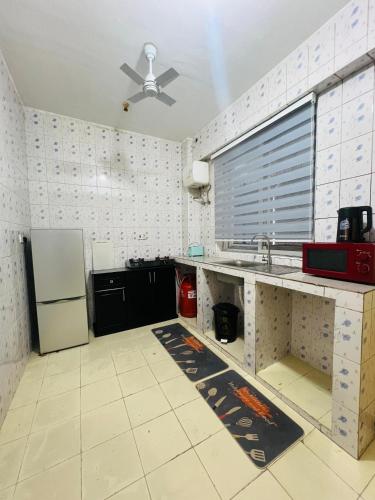 a kitchen with a sink and a refrigerator at The Luxe Apartment in Zanzibar City