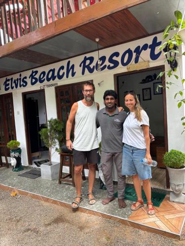 a group of three people standing in front of a beach resort at Elvis Beach Resort in Trincomalee