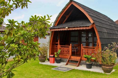 a gazebo with a black roof in a garden at Munduk Luwih Ecolodge Bedugul by AGATA in Tabanan