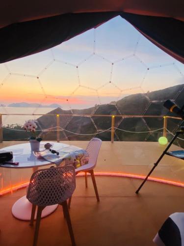 a tent with a table and chairs on a balcony at Palmaria Sky Bubbles Room in Ponza