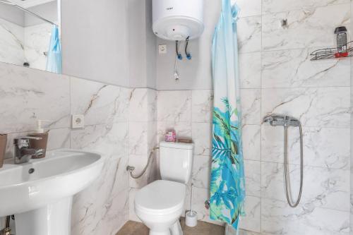 a bathroom with a toilet and a sink and a shower at Fazenda Akwa Baseini in Solotvyno