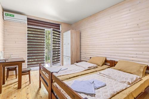 a bedroom with two beds and a desk and a window at Fazenda Akwa Baseini in Solotvyno
