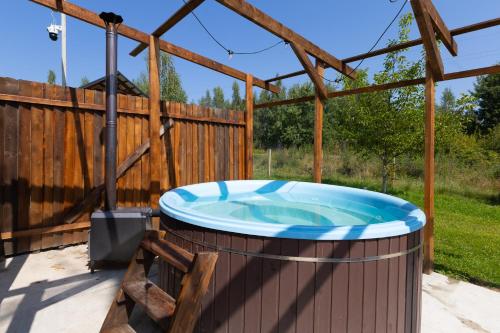 a hot tub in a backyard with a wooden fence at Fazenda Akwa Baseini in Solotvyno