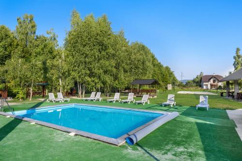 a swimming pool with lounge chairs and a yard at Fazenda Akwa Baseini in Solotvyno