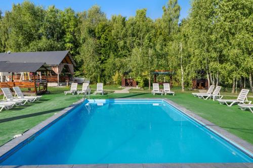 a swimming pool with lounge chairs and a house at Fazenda Akwa Baseini in Solotvyno