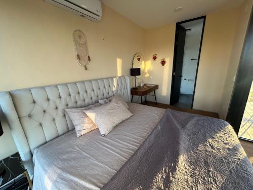 a bedroom with a large bed with a large headboard at Casa Arsha Beachfront Bed & Breakfast in Dzidzantún