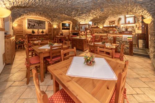 a restaurant with wooden tables and chairs in a room at Chalet Chez Nous in Sauze dʼOulx