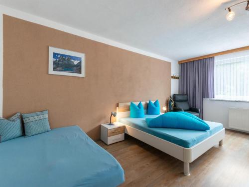 StrengenにあるApartment in Strengen near Ski Slopesのベッドルーム1室(青い枕のベッド2台付)