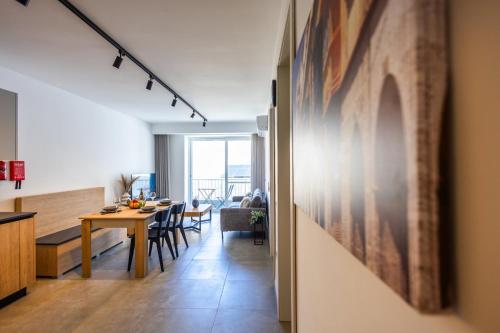 a kitchen and living room with a table and chairs at Downtown Central Apartments in Msida