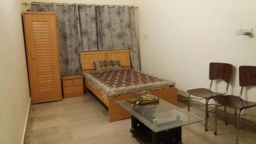 a bedroom with a bed and a table and chairs at Data Guest House in Dargai