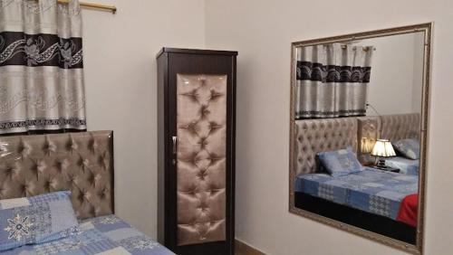 a bedroom with a mirror next to a bed at Data Guest House in Dargai