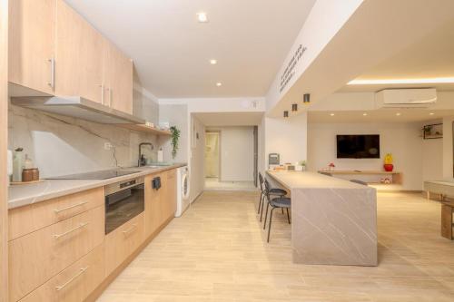 a large kitchen with a counter and a table at Fairytale Apartment in Piraeus