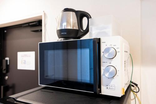 een koffiezetapparaat op de magnetron bij Residence Noa 101 in Fukuoka