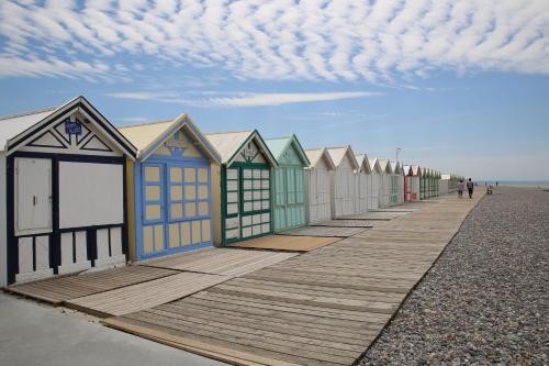 a row of beach huts on the beach at Gîte My Cottage Baie de Somme avec sauna in Cayeux-sur-Mer