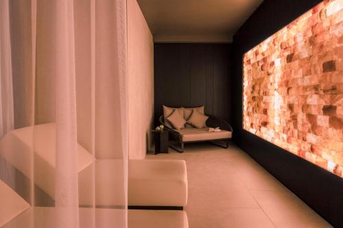 a room with a couch and a brick wall at SCHLOSS Zermatt - CBD & Adaptogenic Spa and Sport Hotel in Zermatt