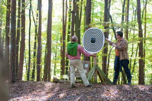 a group of three men playing with a spinning object in the woods at Malerwinkl Restaurant + Kunsthotel in Hatzendorf