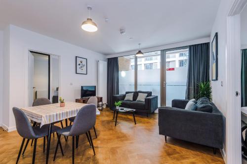 a living room with a table and chairs at Hilltop Serviced Apartments - Ancoats in Manchester