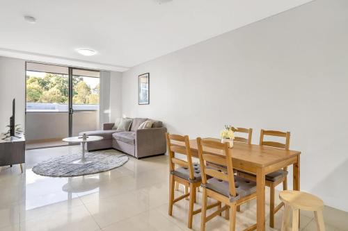 a living room with a wooden table and chairs at 11B Abnb-Style Charming 12 Mins Walk Train STA Free parking2BR in Bankstown