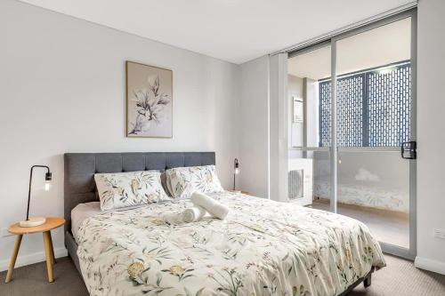 a white bedroom with a large bed and a window at 11B Abnb-Style Charming 12 Mins Walk Train STA Free parking2BR in Bankstown