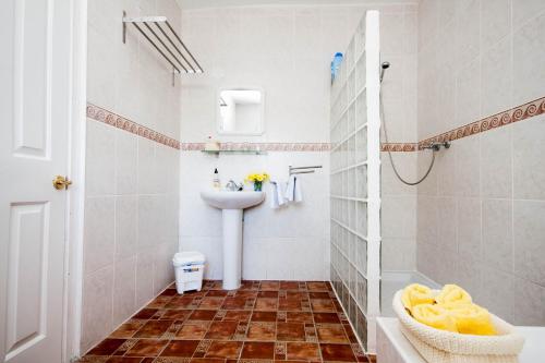 a white bathroom with a sink and a toilet at Dos Alamos B&B in Alora