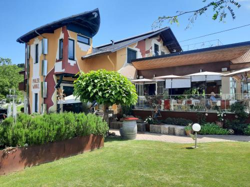 a building with a lawn in front of it at Malerwinkl Restaurant + Kunsthotel in Hatzendorf