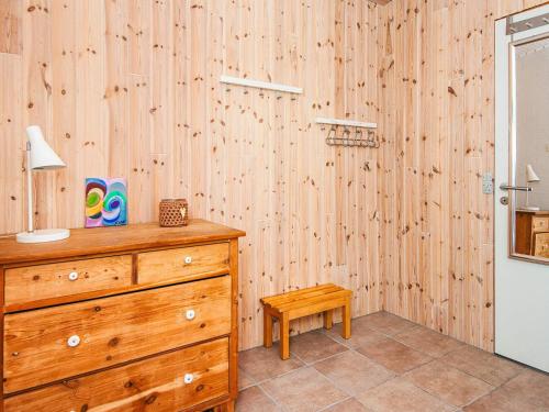 a bedroom with a dresser and a wooden wall at 2 person holiday home in Tarm-By Traum in Fjerbæk