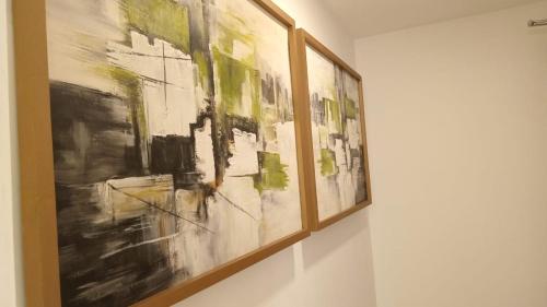 a group of paintings hanging on a wall at Colombo, Trizen Luxury Apartments, Sri Lanka in Colombo