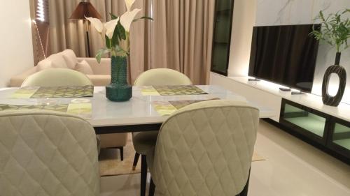a dining room table with chairs and a television at Colombo, Trizen Luxury Apartments, Sri Lanka in Colombo