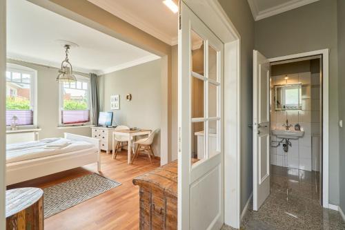 a bedroom with a bed and a desk in a room at Haus Sonnenhof Sonnenhof 10 - Joni in Kellenhusen