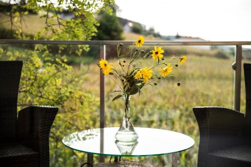 a vase of yellow flowers sitting on a table at Malerwinkl Restaurant + Kunsthotel in Hatzendorf