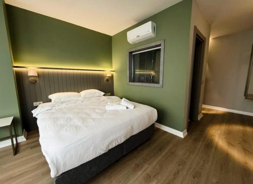 a bedroom with a large bed with a green wall at OTTO X Hotel in Kavaklıdere