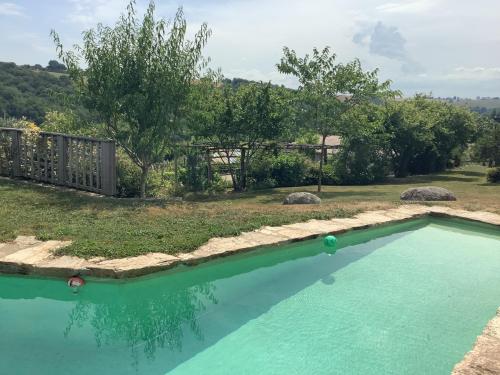 a swimming pool in a yard with trees at Chambre d hôtes GRANAL in Saint-Julien-Gaulène