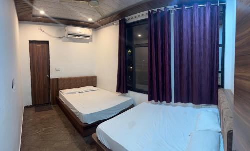 a small room with two beds and a window at Shree Banke Bihari Place in Khātu