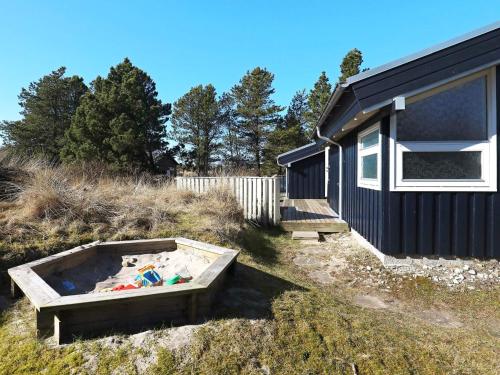 a small house with a sandbox in the yard at 8 person holiday home in Bindslev-By Traum in Bindslev