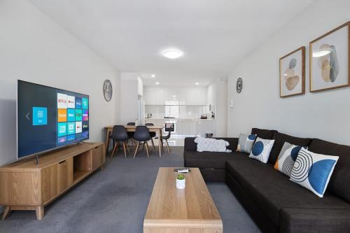 a living room with a couch and a tv at 38HP Abnb-Style Quality Hurlstone Park Free parking 2BR in Sydney