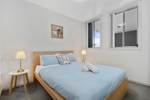 a bedroom with a large bed with two windows at 38HP Abnb-Style Quality Hurlstone Park Free parking 2BR in Sydney
