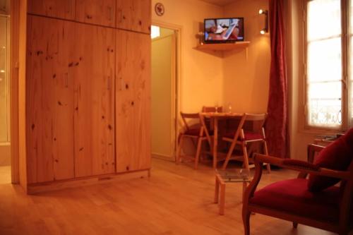 a living room with a large wooden cabinet and a table at Saint Michel Notre Dame in Paris