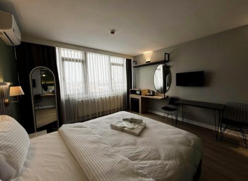 a bedroom with a large white bed with a mirror at OTTO X Hotel in Kavaklıdere