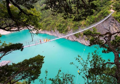 a suspension bridge over a river with blue water at Gite 2 personnes Lac Monteynard - Treffort Isère in Treffort