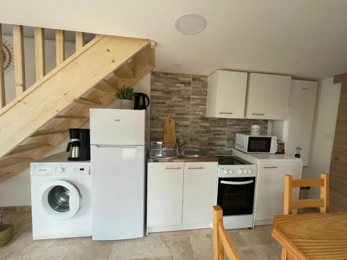 a kitchen with white appliances and a staircase at Gite 2 personnes Lac Monteynard - Treffort Isère in Treffort