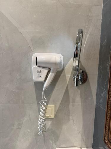 a white phone is hanging on a wall at Nizami Hostel in Baku