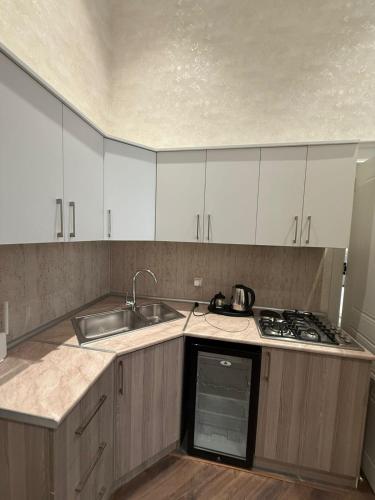 a kitchen with white cabinets and a sink and a stove at Nizami Hostel in Baku