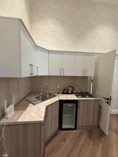 a kitchen with white cabinets and a sink at Nizami Hostel in Baku