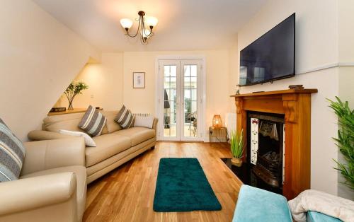 a living room with a couch and a fireplace at Castle Square Cottage - Beachside Retreat in The Mumbles